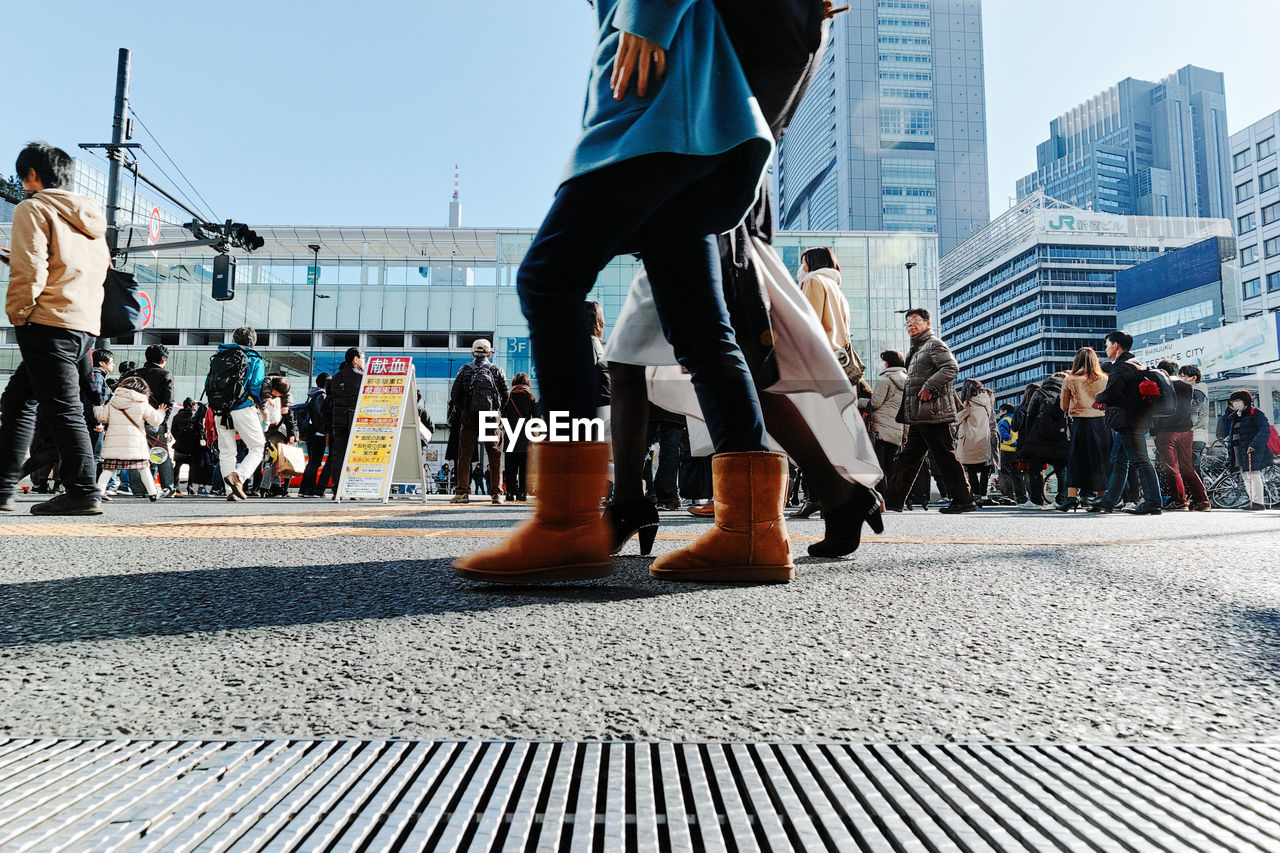 LOW SECTION OF MAN AND WOMAN STANDING BY CITY