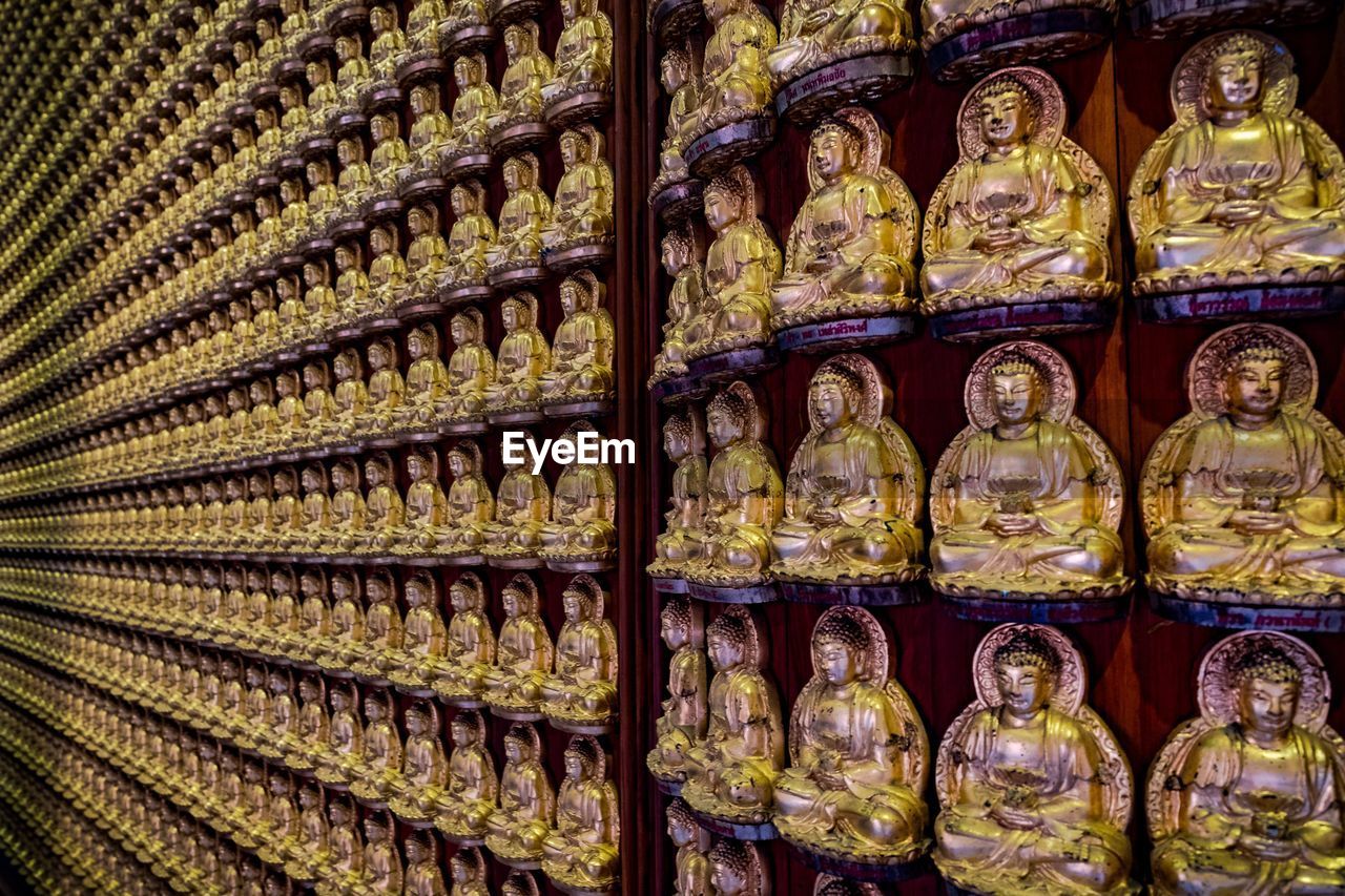 Golden buddha sculptures arranged in temple