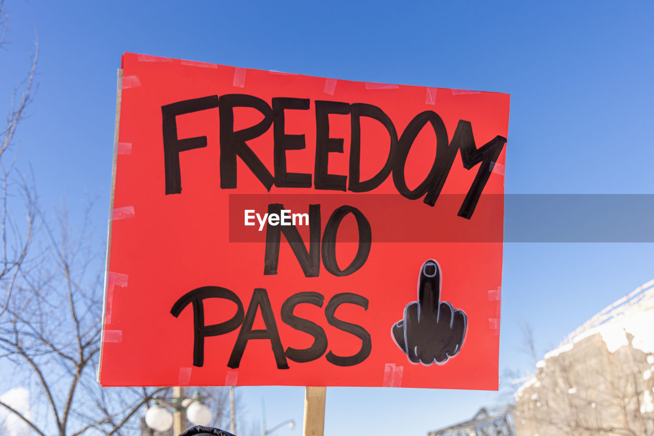 sign, communication, text, red, sky, nature, blue, snow, mountain, clear sky, western script, signage, tree, no people, winter, day, road sign, advertising, outdoors, cold temperature, road, sunny