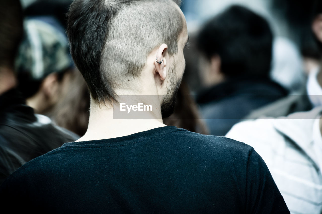 Rear view of hipster with hairstyle in crowd