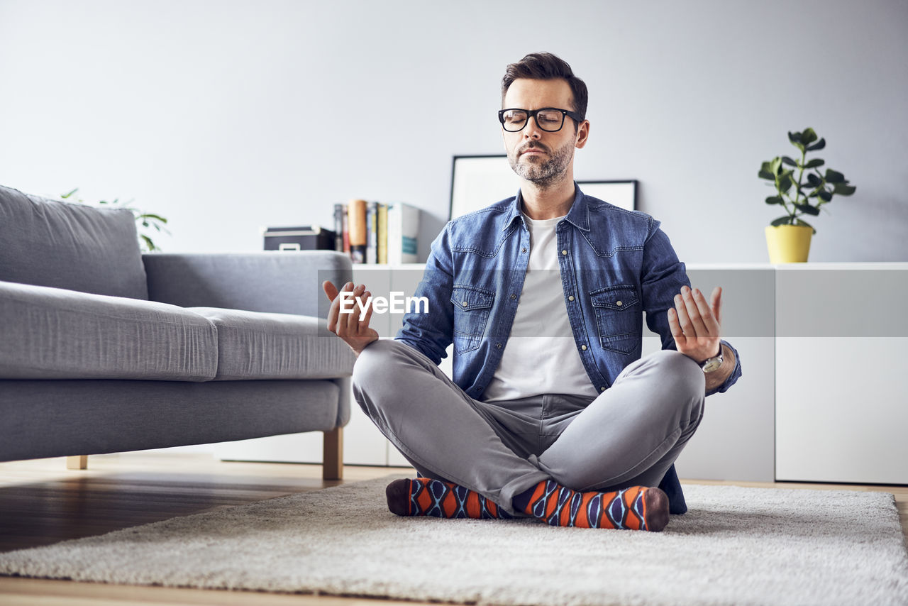 Relaxed man meditating at home