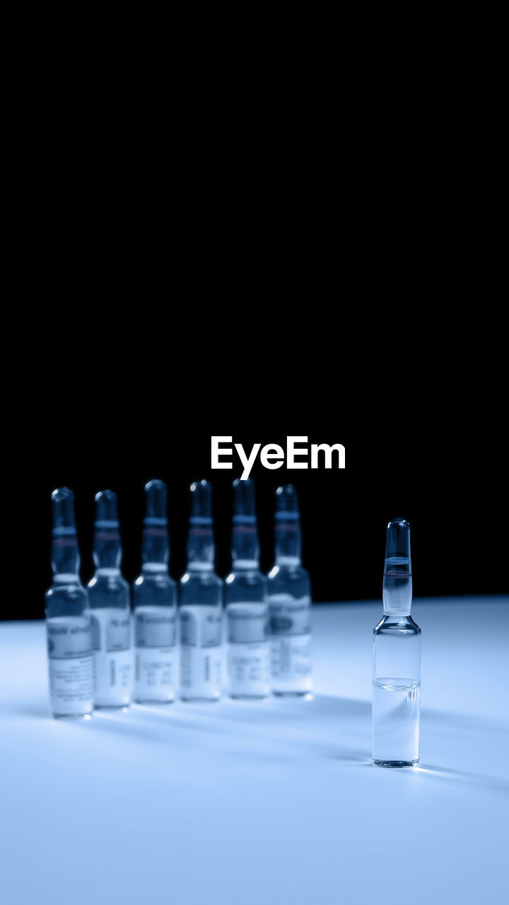 Medicine bottles on table against black background