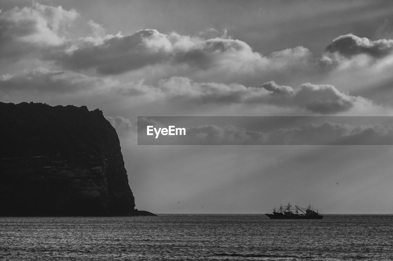 SCENIC VIEW OF SEA BY ROCKS AGAINST SKY