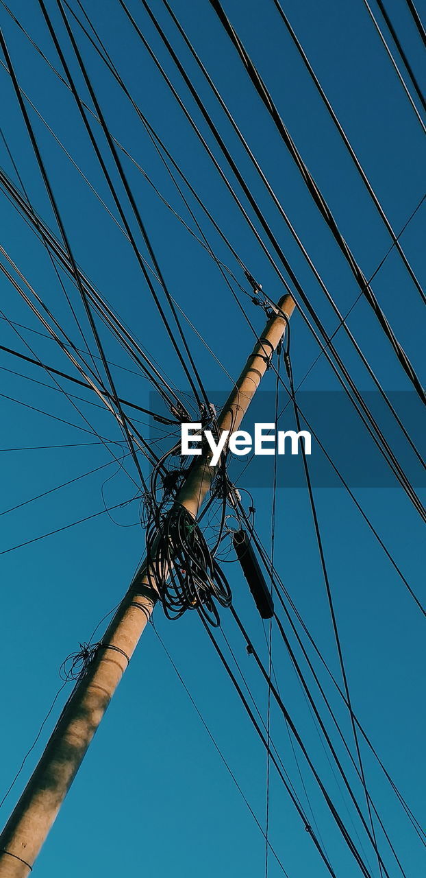 Low angle view of cables against clear blue sky