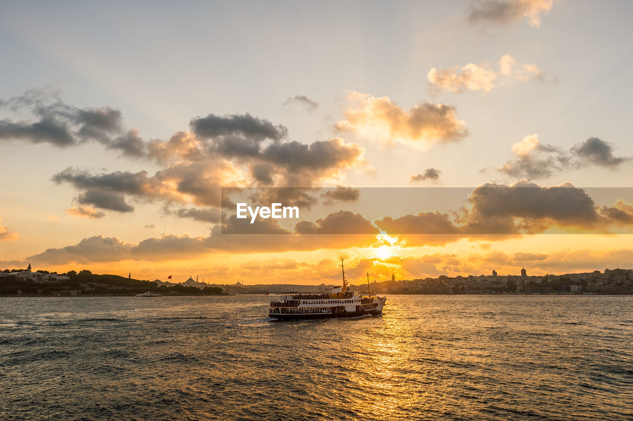 Boat on sea against sky during sunset