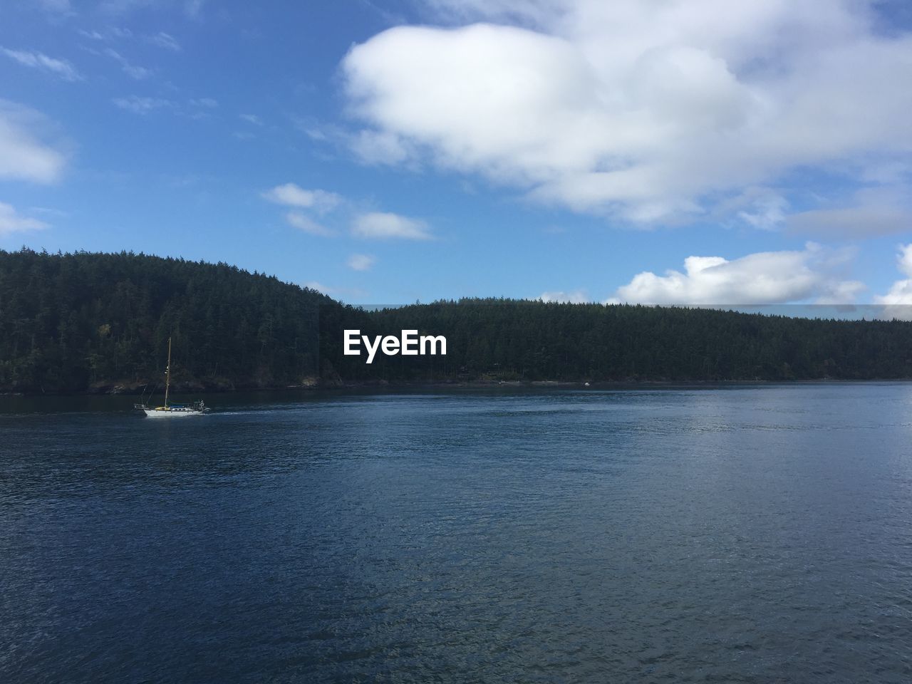 Scenic view of lake by mountains against sky