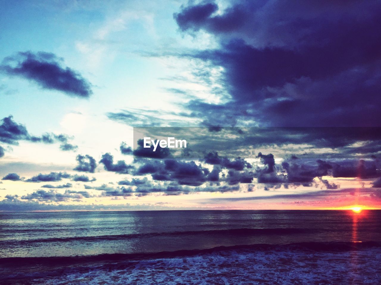 SCENIC VIEW OF BEACH AGAINST SKY AT SUNSET