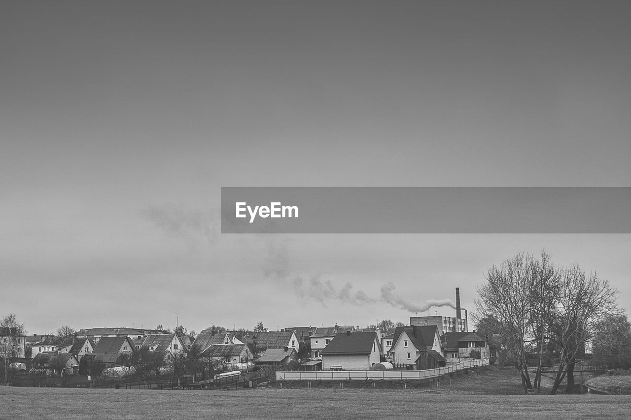 Houses by field against sky