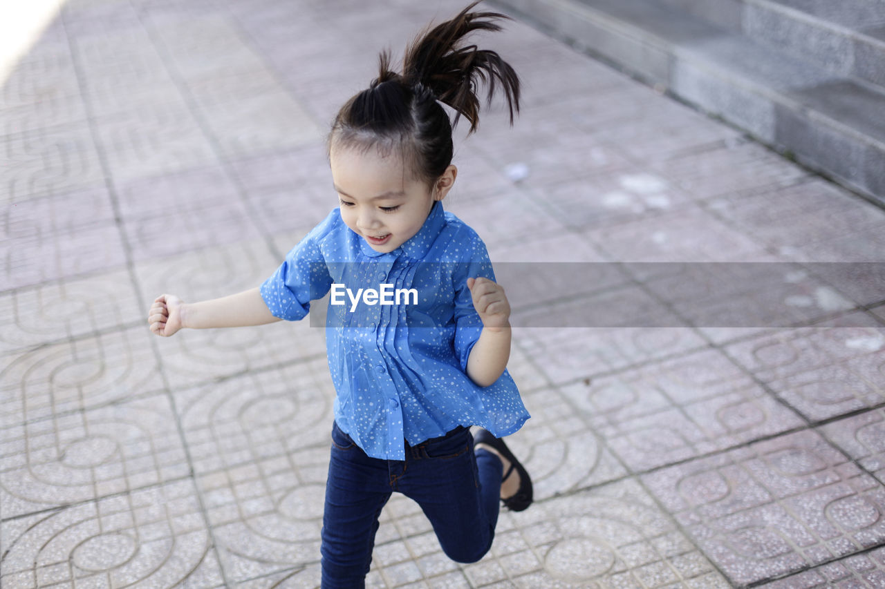 HIGH ANGLE VIEW OF BOY PLAYING ON THE FLOOR