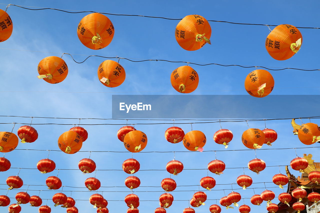 Low angle view of lanterns hanging against sky