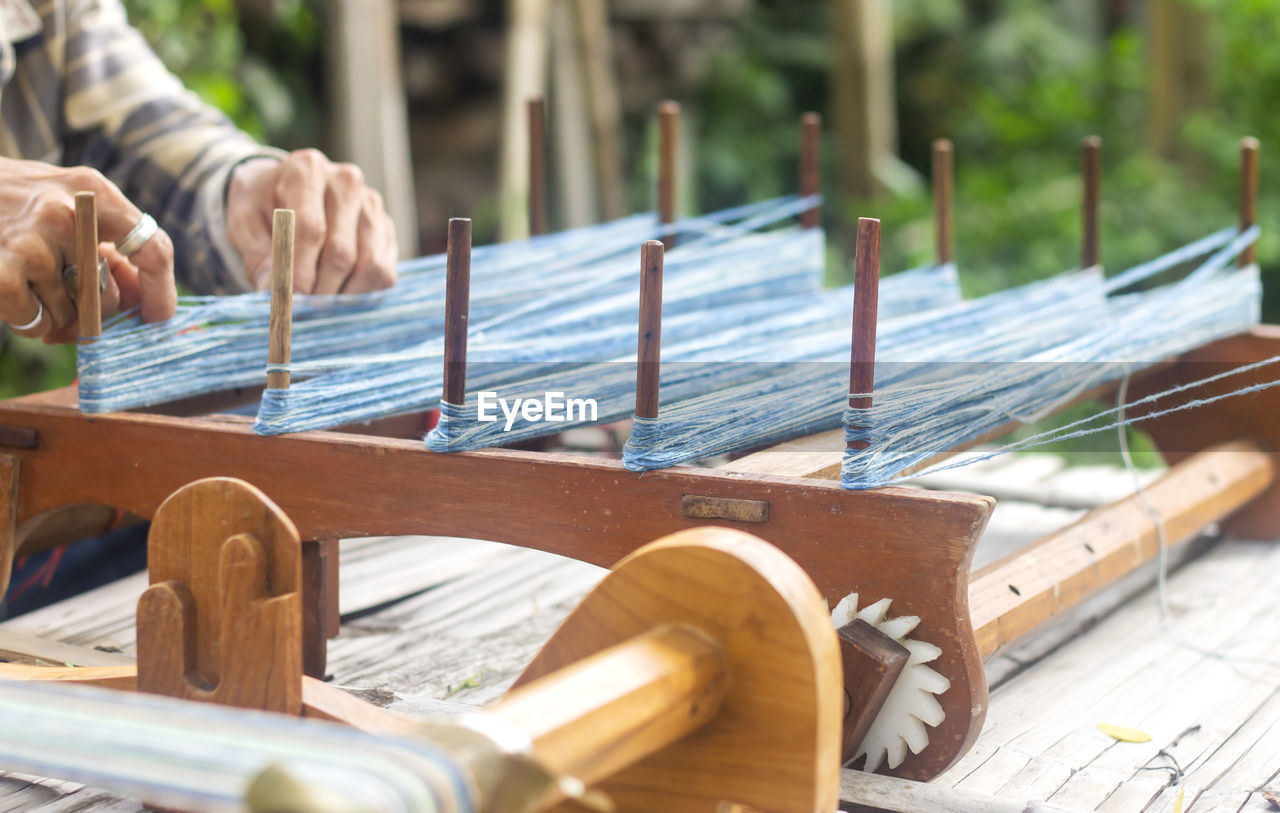 Close-up of hands working on loom