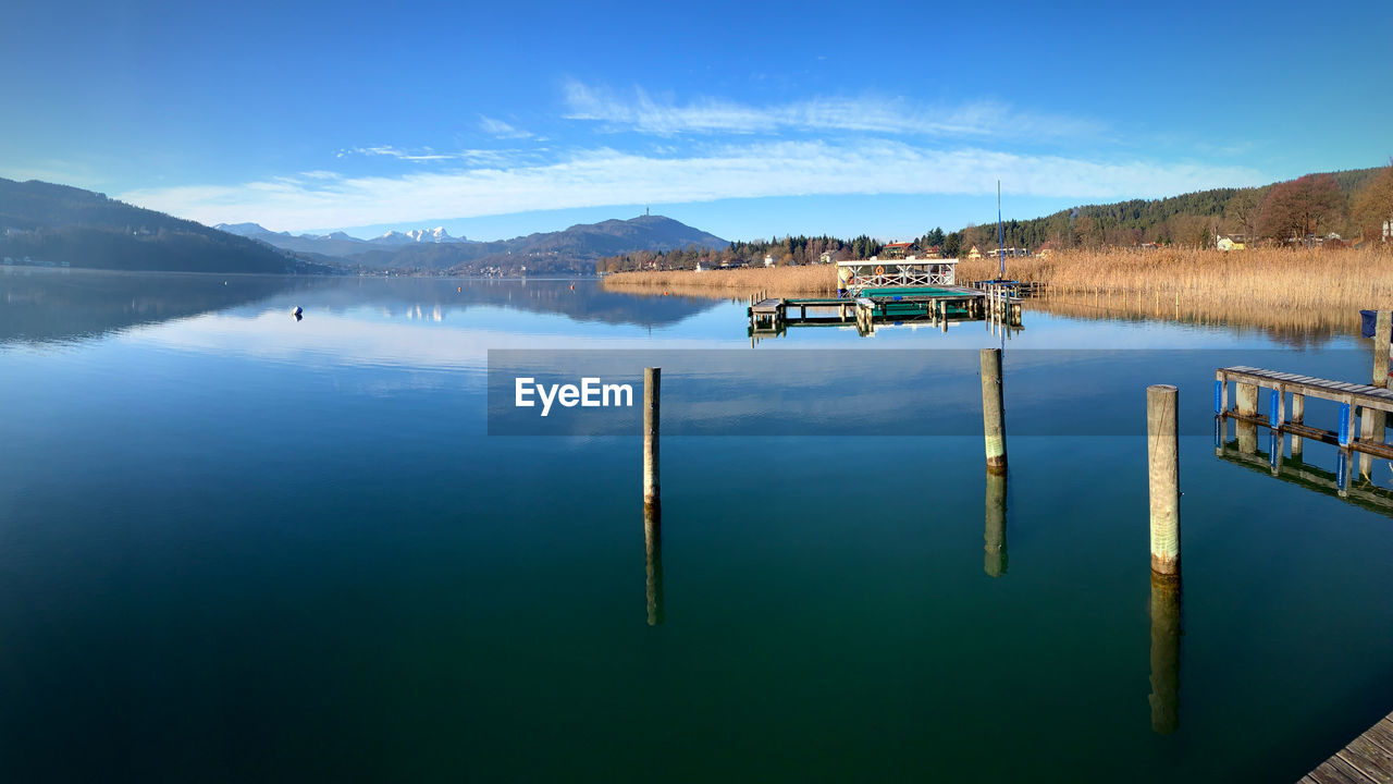 WOODEN POST IN LAKE AGAINST SKY