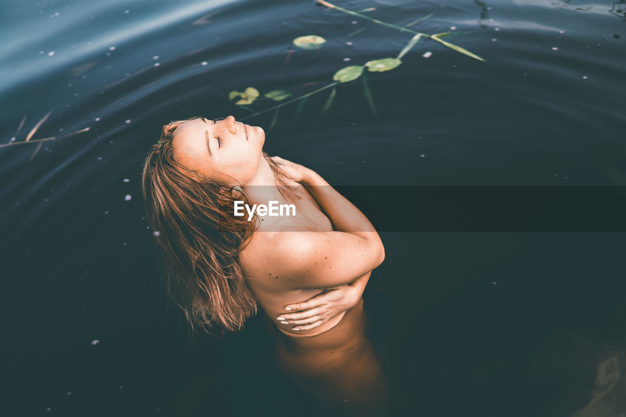 High angle view of naked woman in lake
