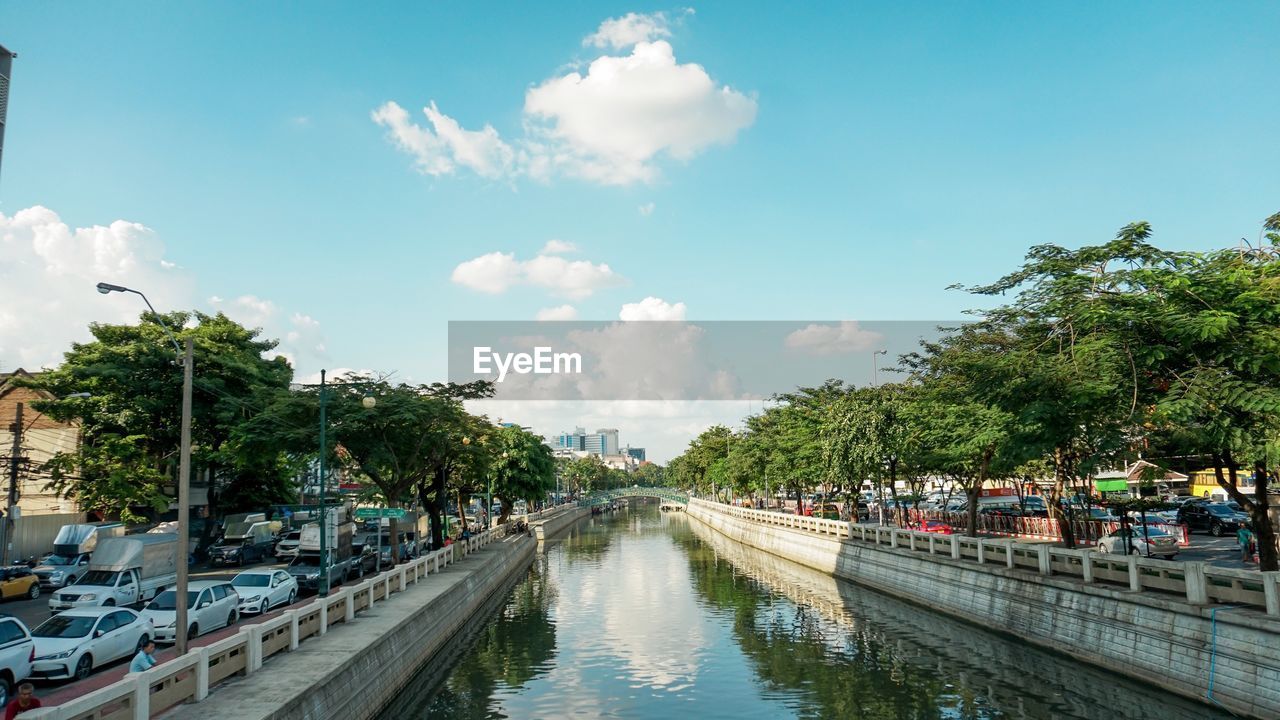 Panoramic view of canal in city against sky