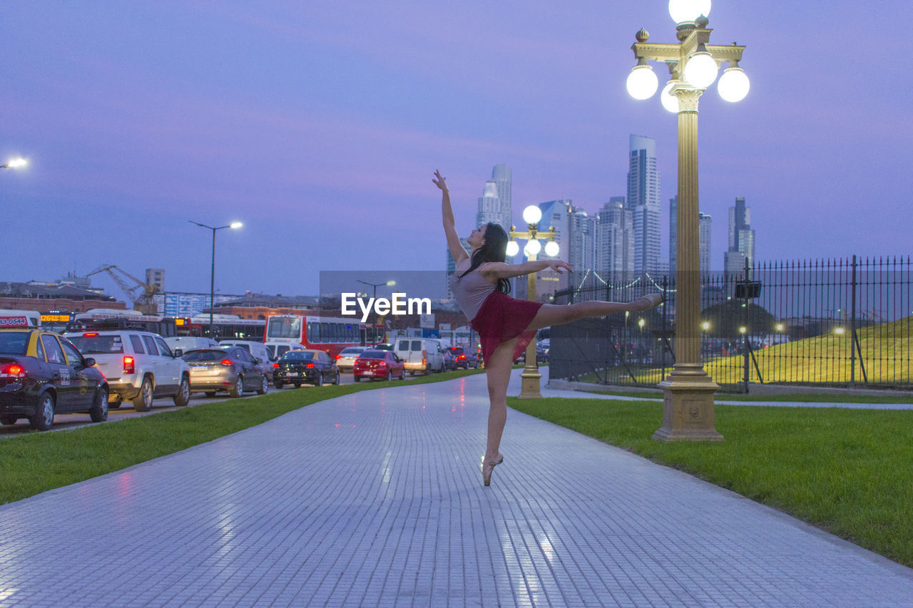 Female ballet dancer on footpath in city
