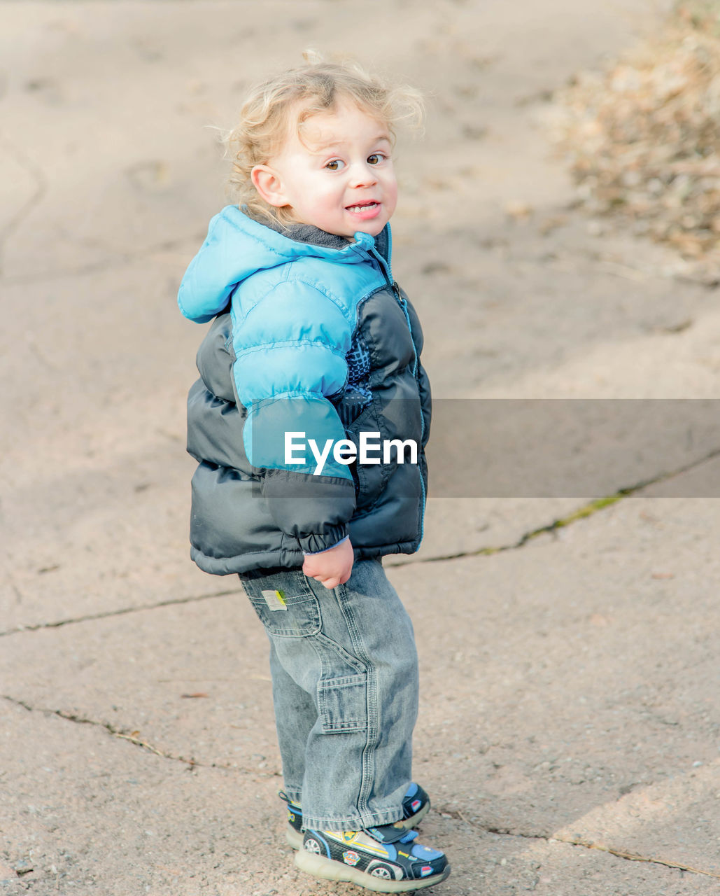 PORTRAIT OF CUTE SMILING BOY STANDING OUTDOORS