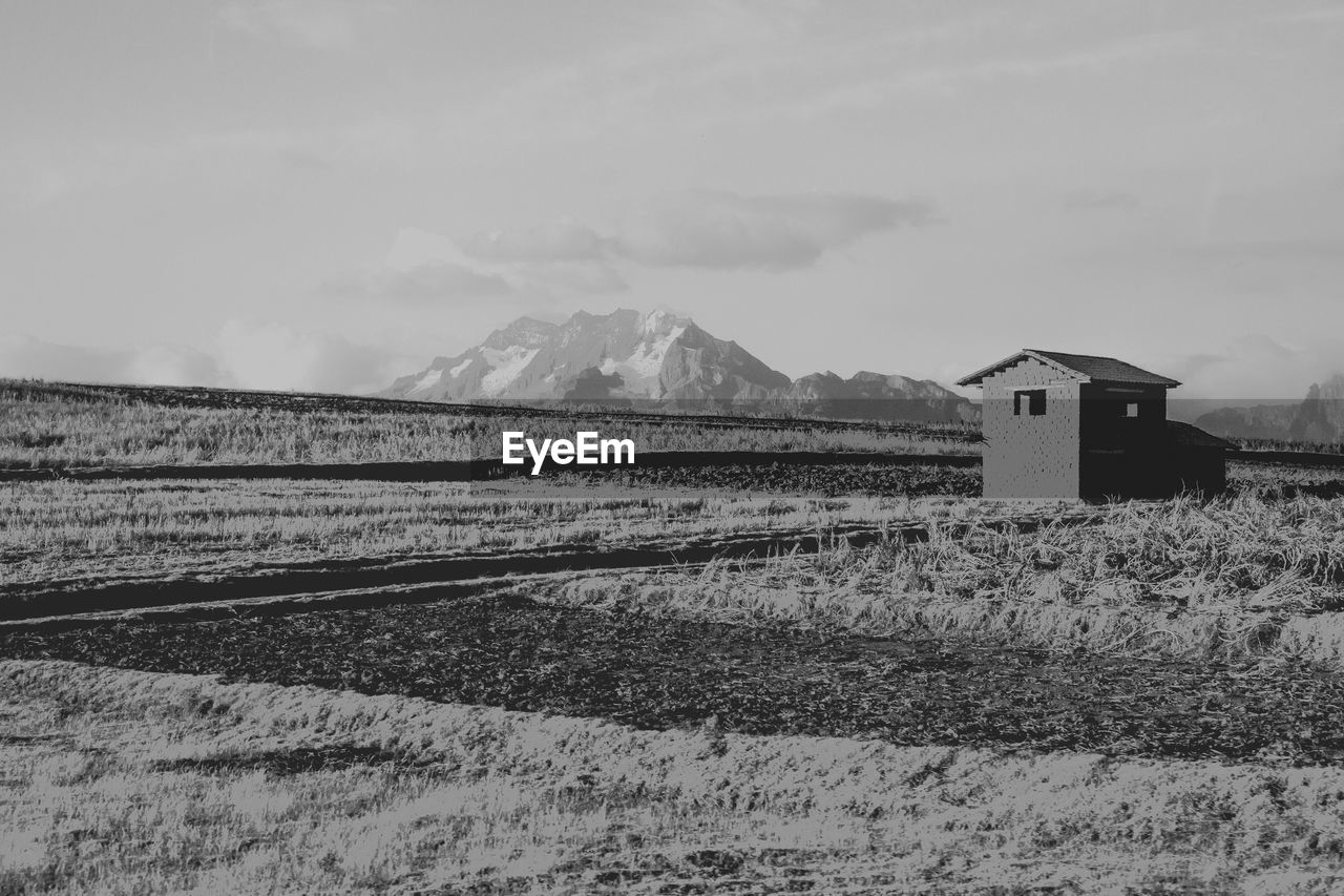 HOUSES ON FIELD AGAINST SKY