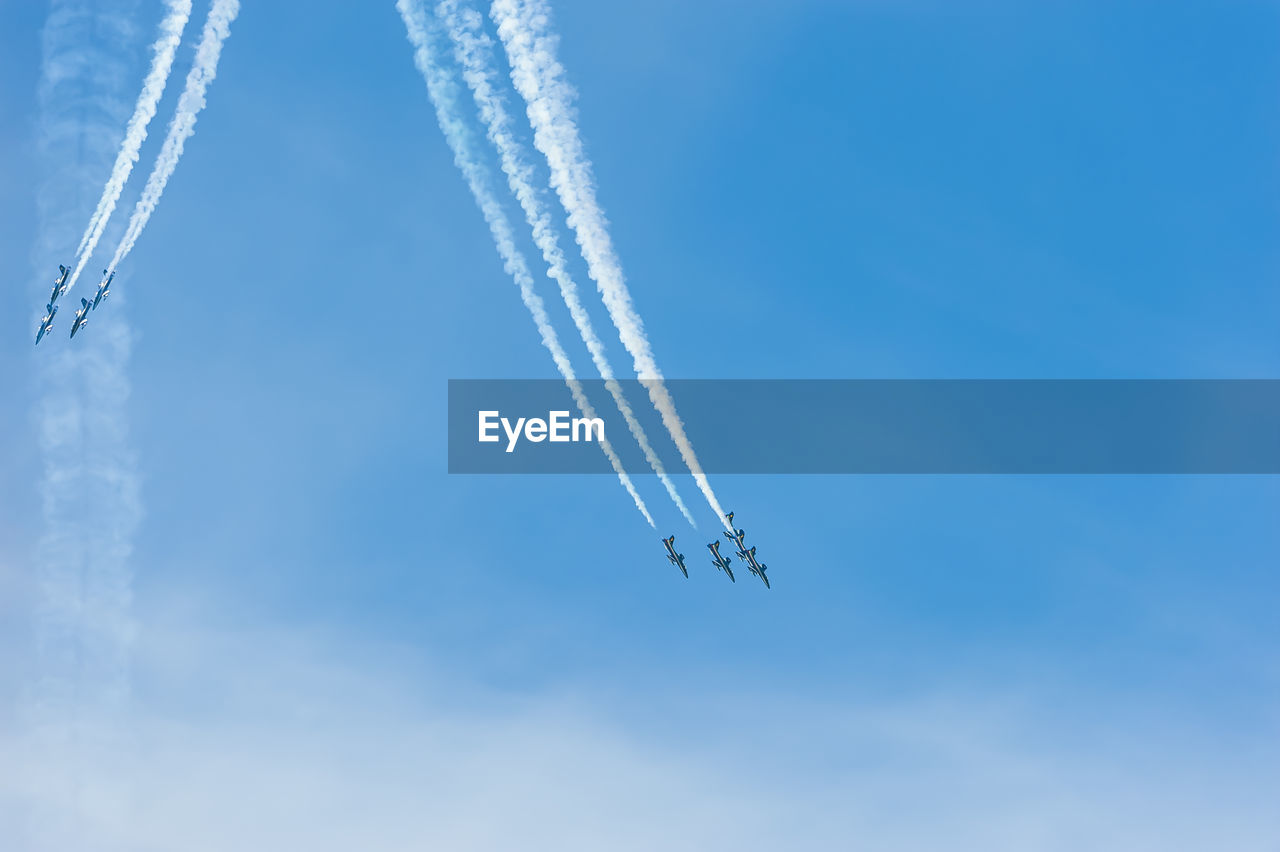 Low angle view of airplane flying against clear blue sky