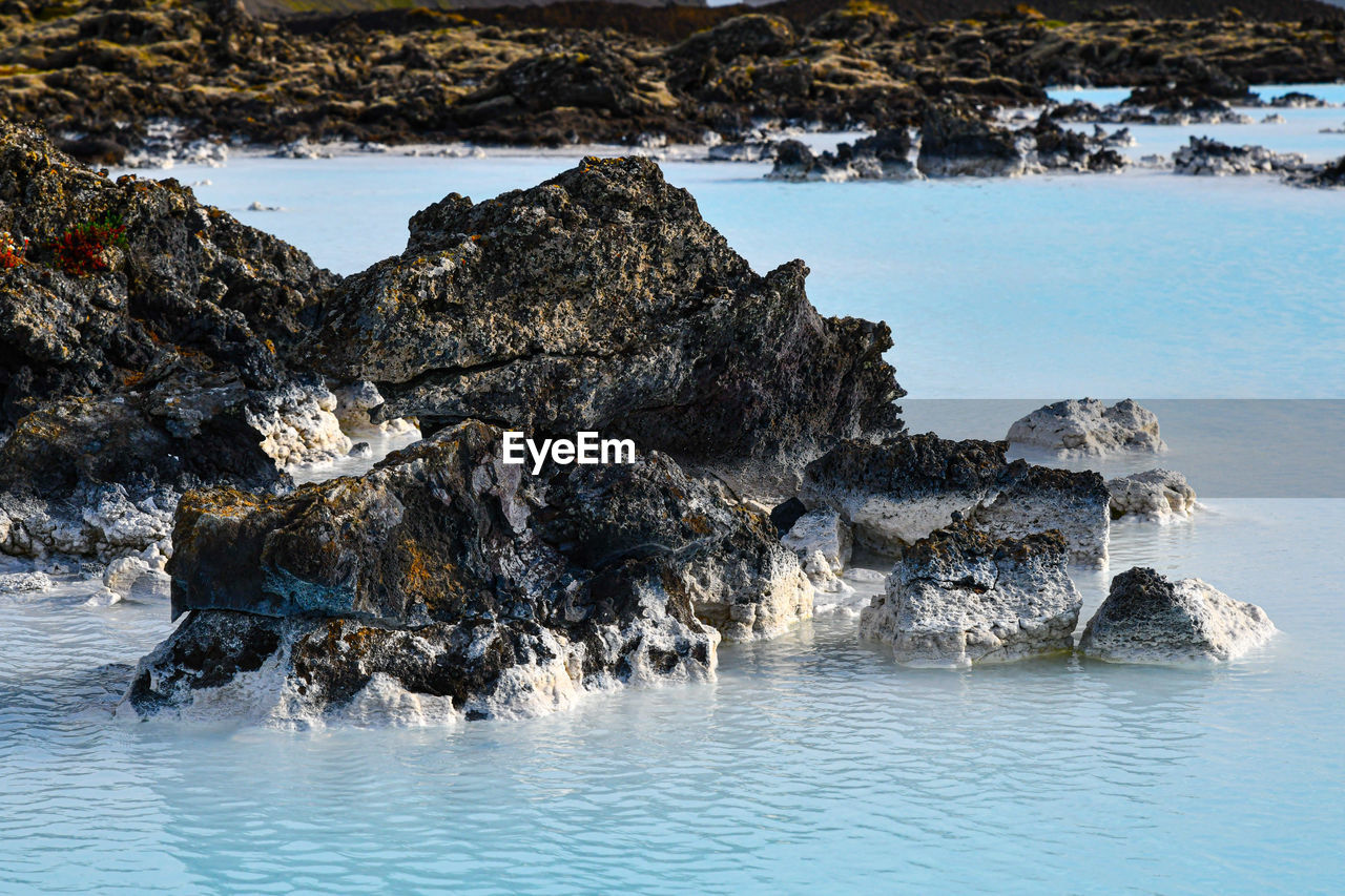 Scenic view of sea against rock formation. iceland blue lagoon