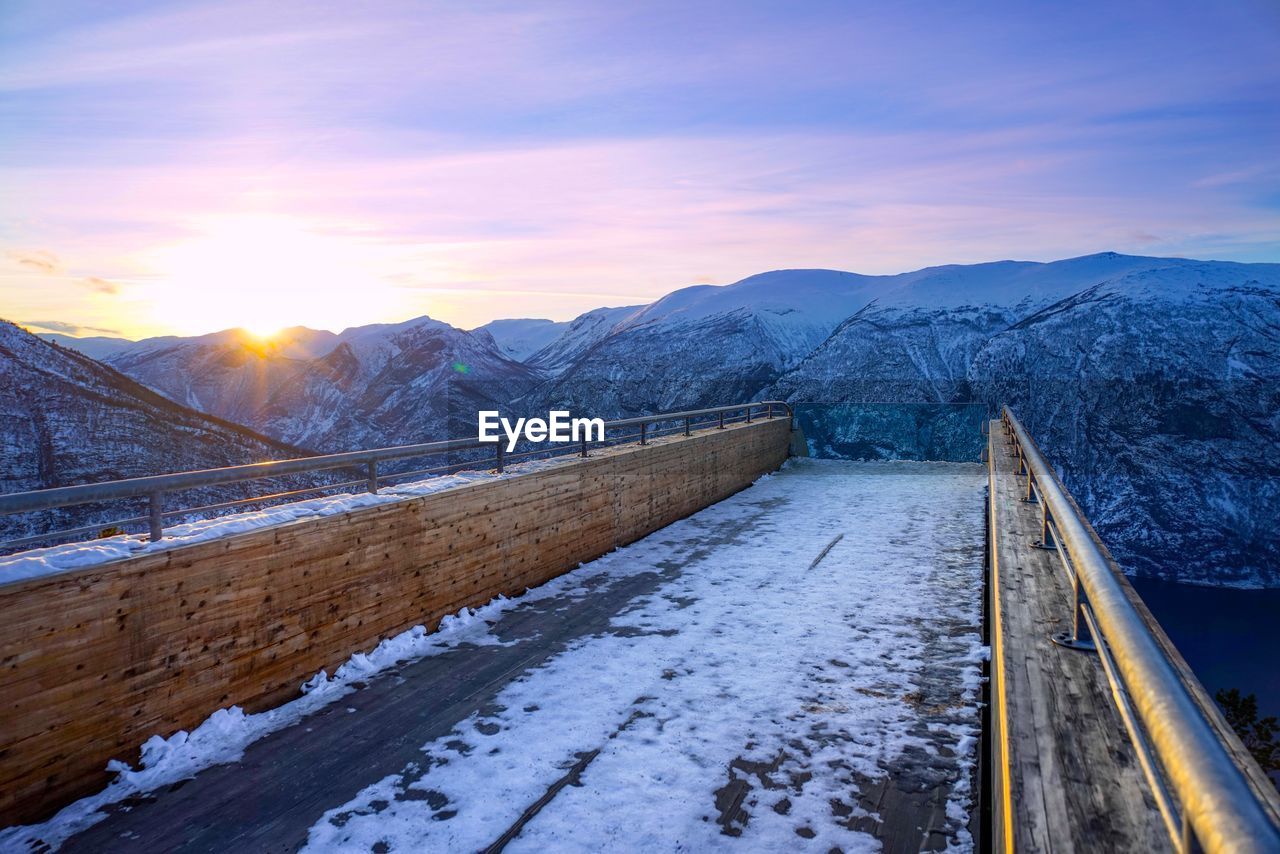 Scenic view of snowcapped mountains against sky during sunset