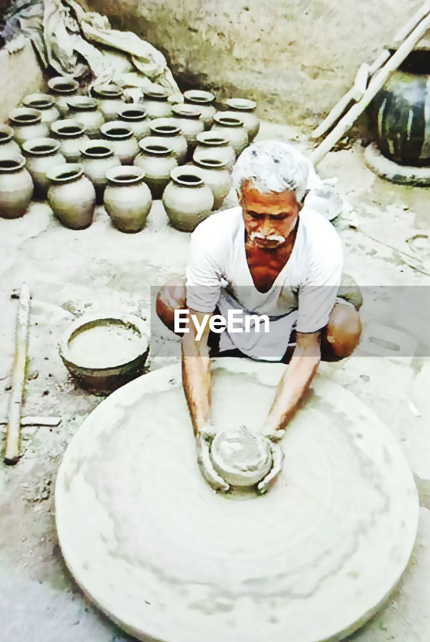 HIGH ANGLE VIEW OF MAN STANDING BY FOOD