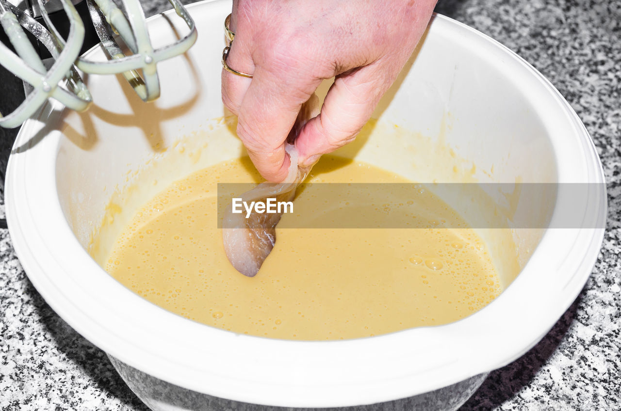 Close-up of hand holding fish in bowl