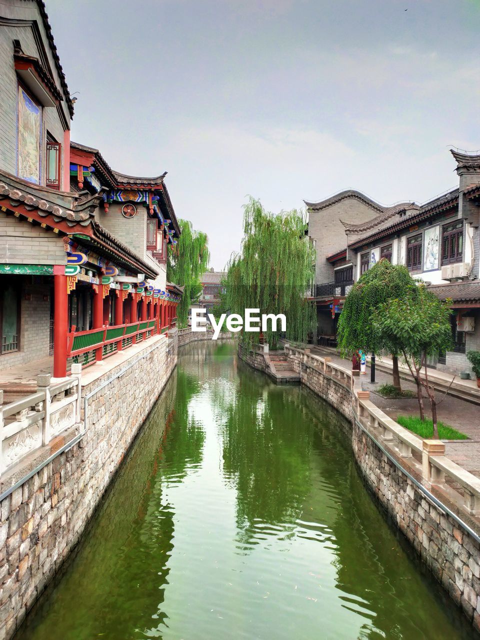 Bridge over river amidst buildings against sky