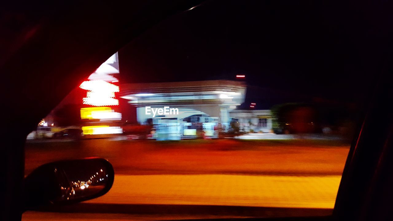 BLURRED MOTION OF CAR ON ILLUMINATED STREET