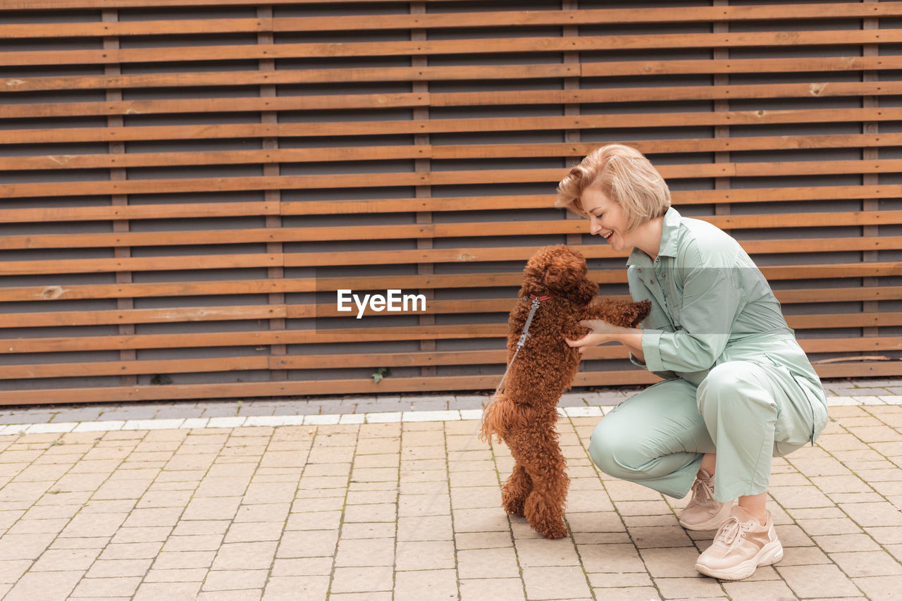 Man with dog sitting against wall