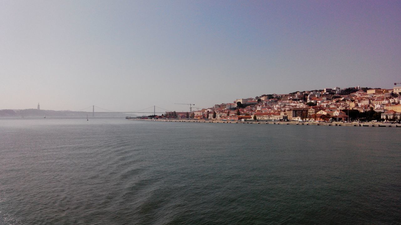 Sea by buildings against sky