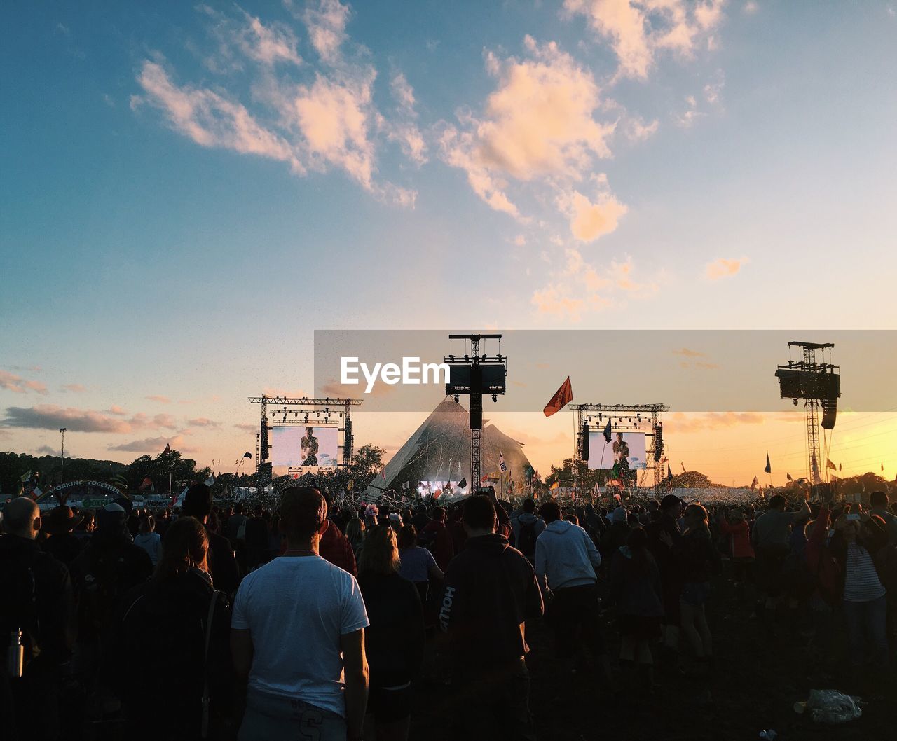 Crowd enjoying at music concert against sky