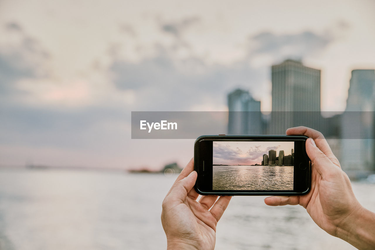 Phone taking picture of new york city skyline at sunset.