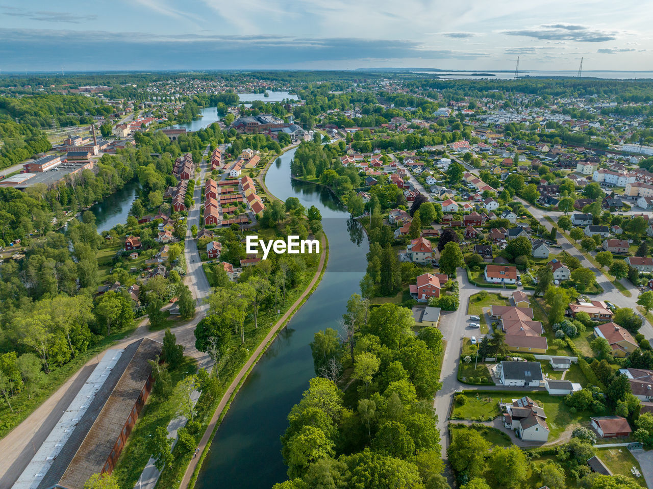 aerial photography, bird's-eye view, city, architecture, residential area, aerial view, landscape, environment, nature, cityscape, built structure, high angle view, building exterior, water, sky, building, plant, cloud, land, scenics - nature, road, neighbourhood, tree, residential district, transportation, travel destinations, travel, outdoors, street, horizon, suburb, beauty in nature, no people, sea, urban skyline, town, tourism, day, house, summer, green, business finance and industry, field