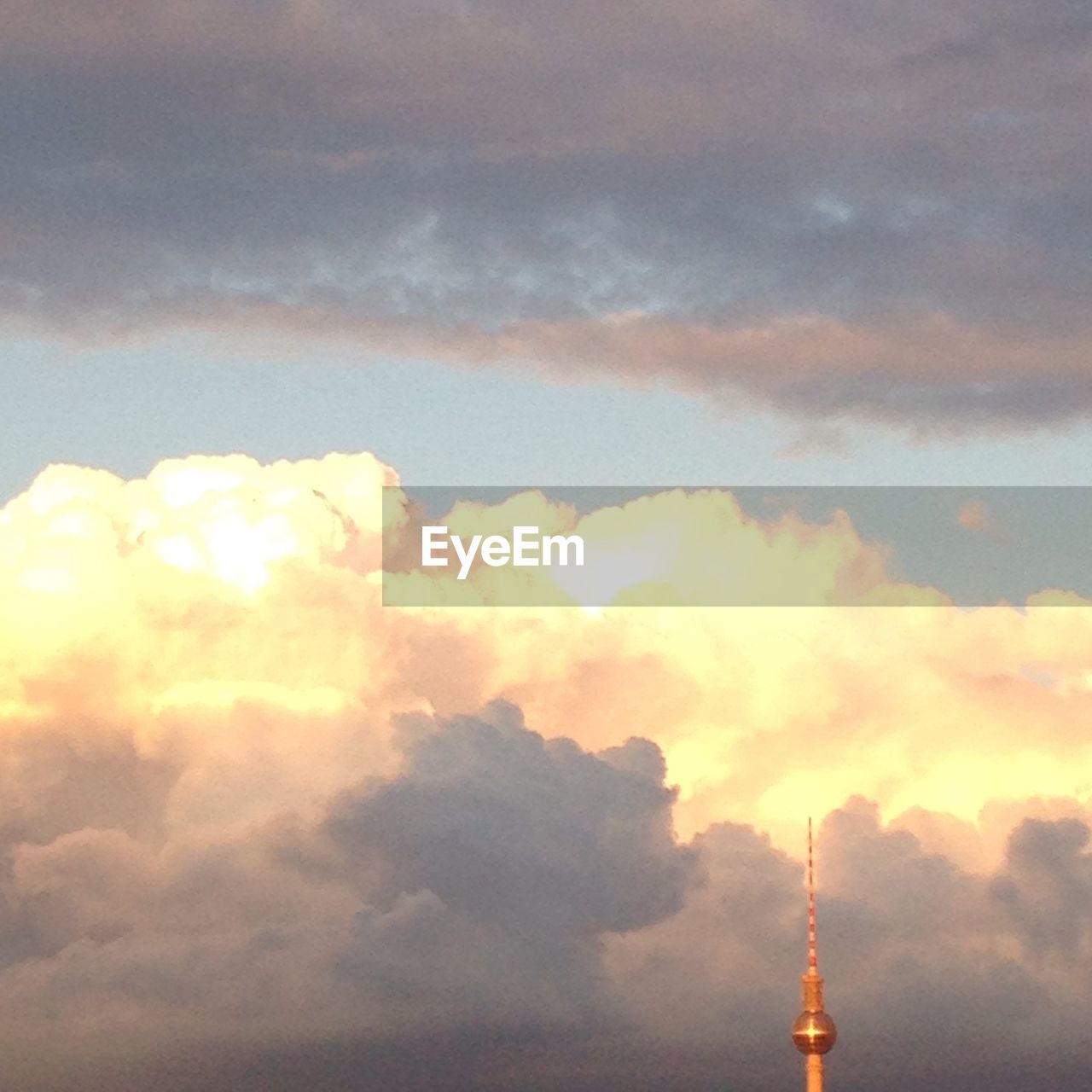 High section of fernsehturm against cloudy sky during sunset