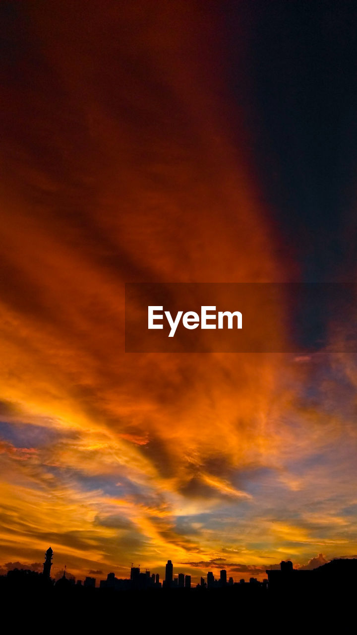 SCENIC VIEW OF SILHOUETTE BUILDINGS AGAINST DRAMATIC SKY