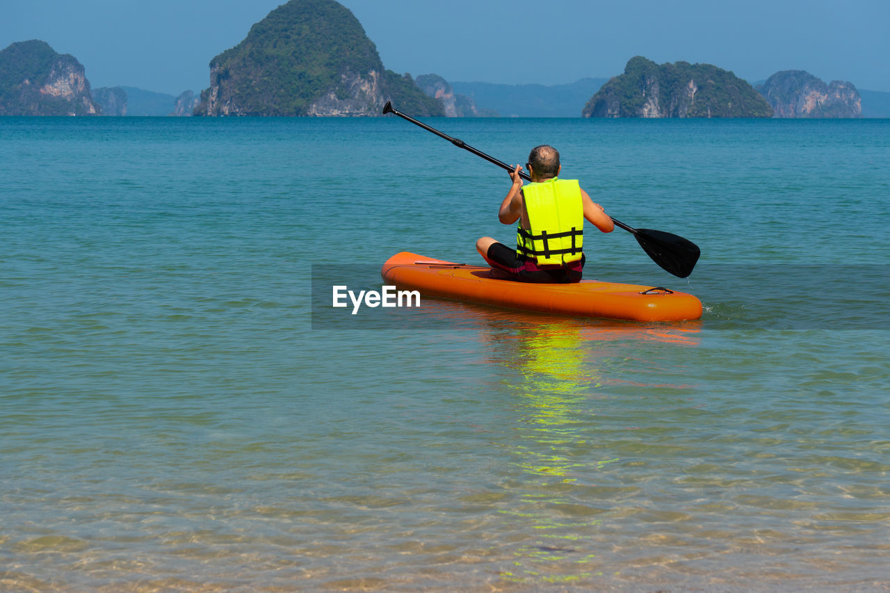 Man rowing boat in sea