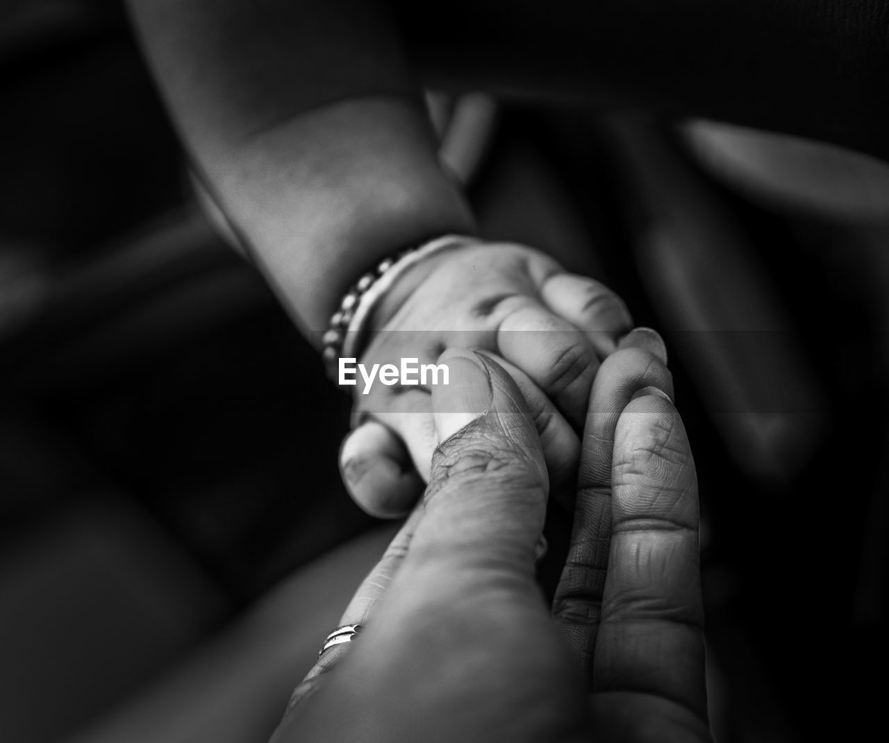 Close-up of woman holding baby hand