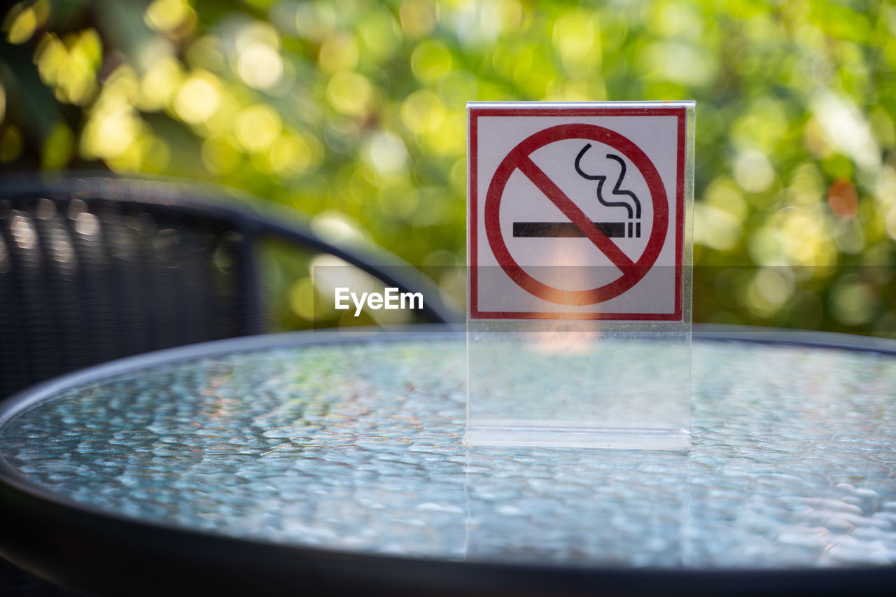 Close-up of no smoking sign on table