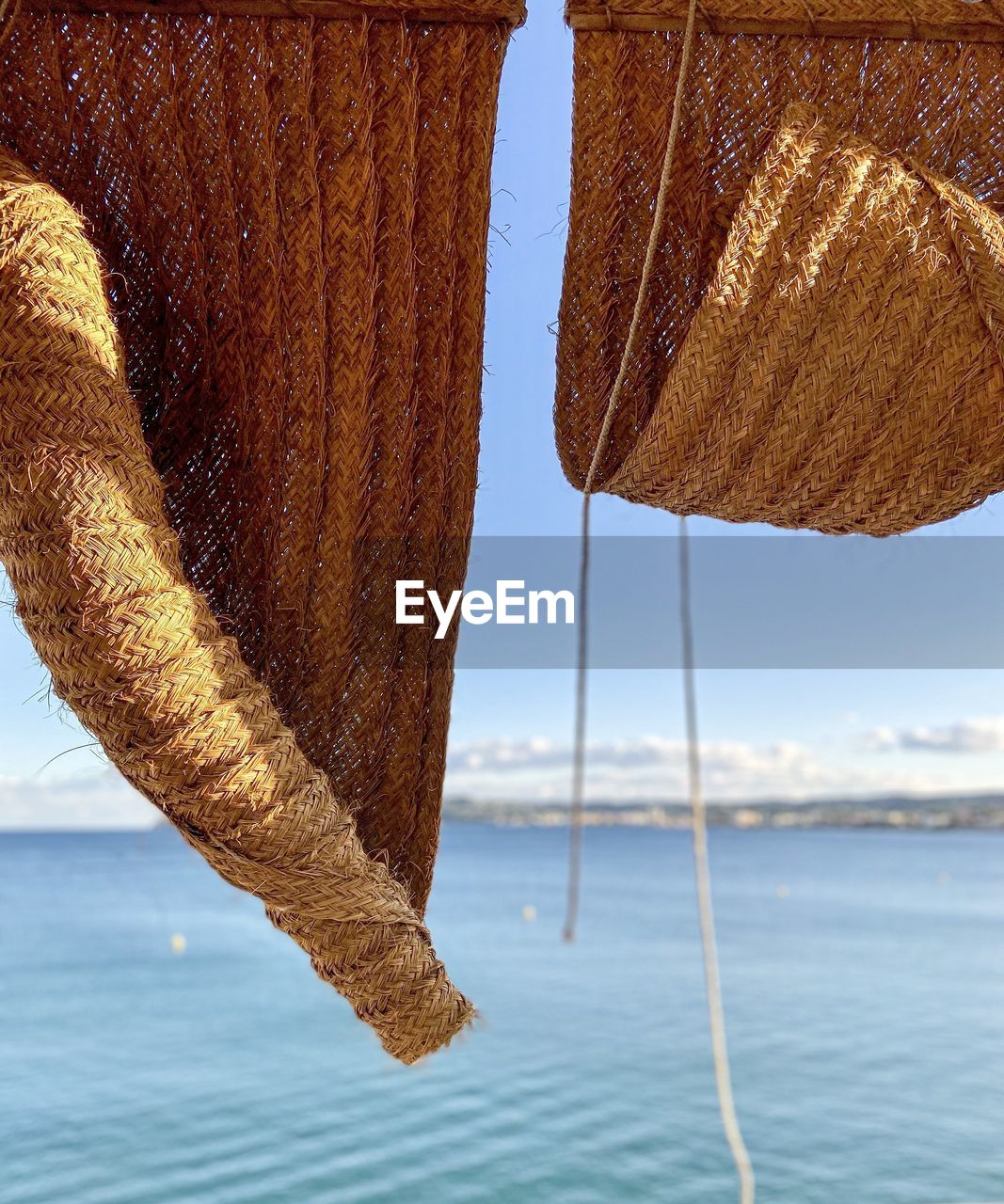 Close-up of basket on beach against sky