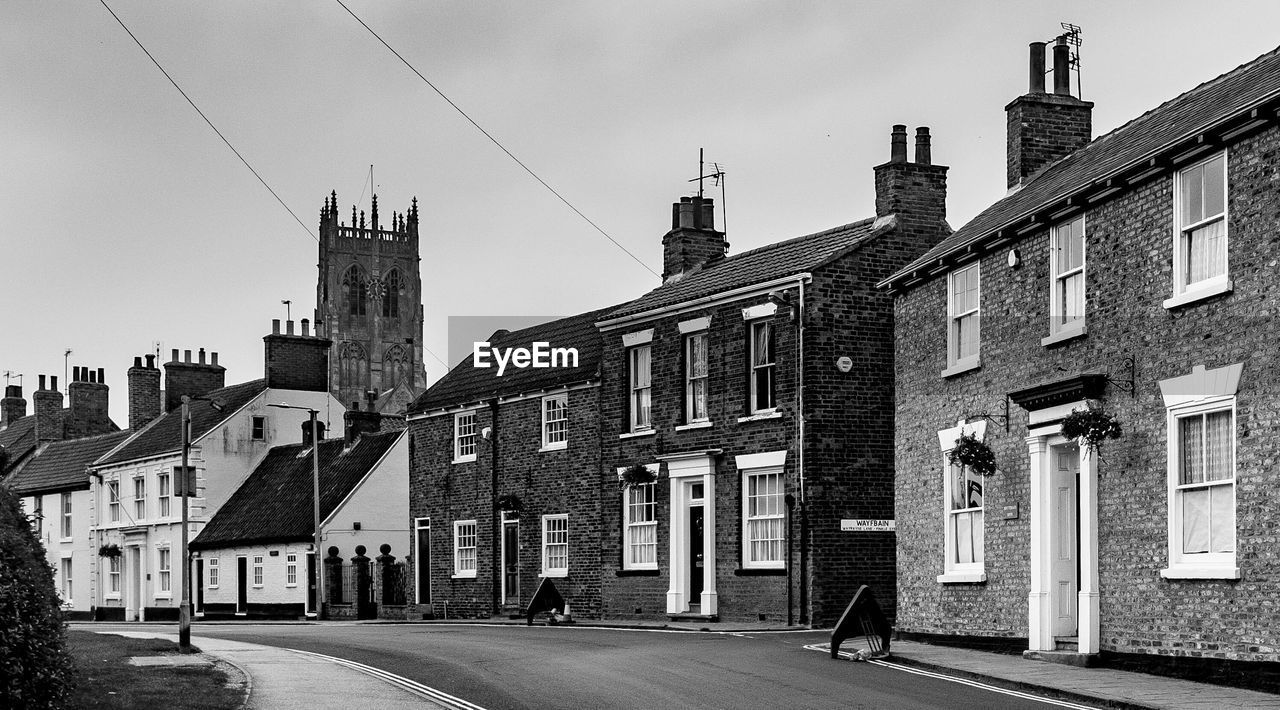 Houses by street against sky