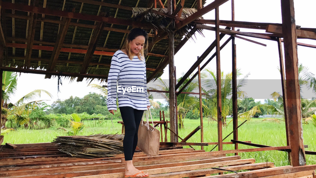 Full length of woman standing on wood