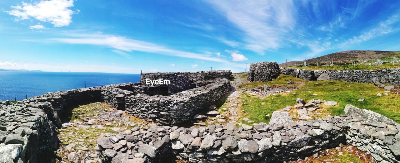 SCENIC VIEW OF SEA BY ROCKS AGAINST SKY