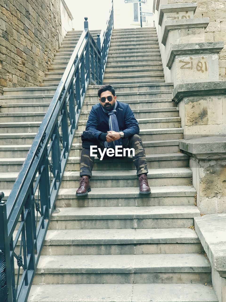 LOW ANGLE VIEW OF MAN SITTING ON STEPS