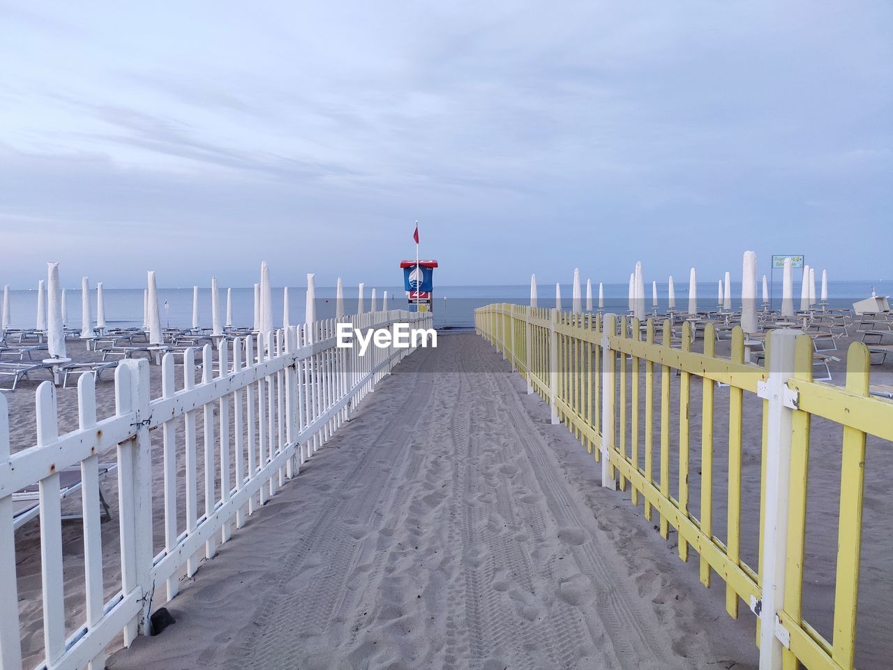 Footpath on beach over sea against sky