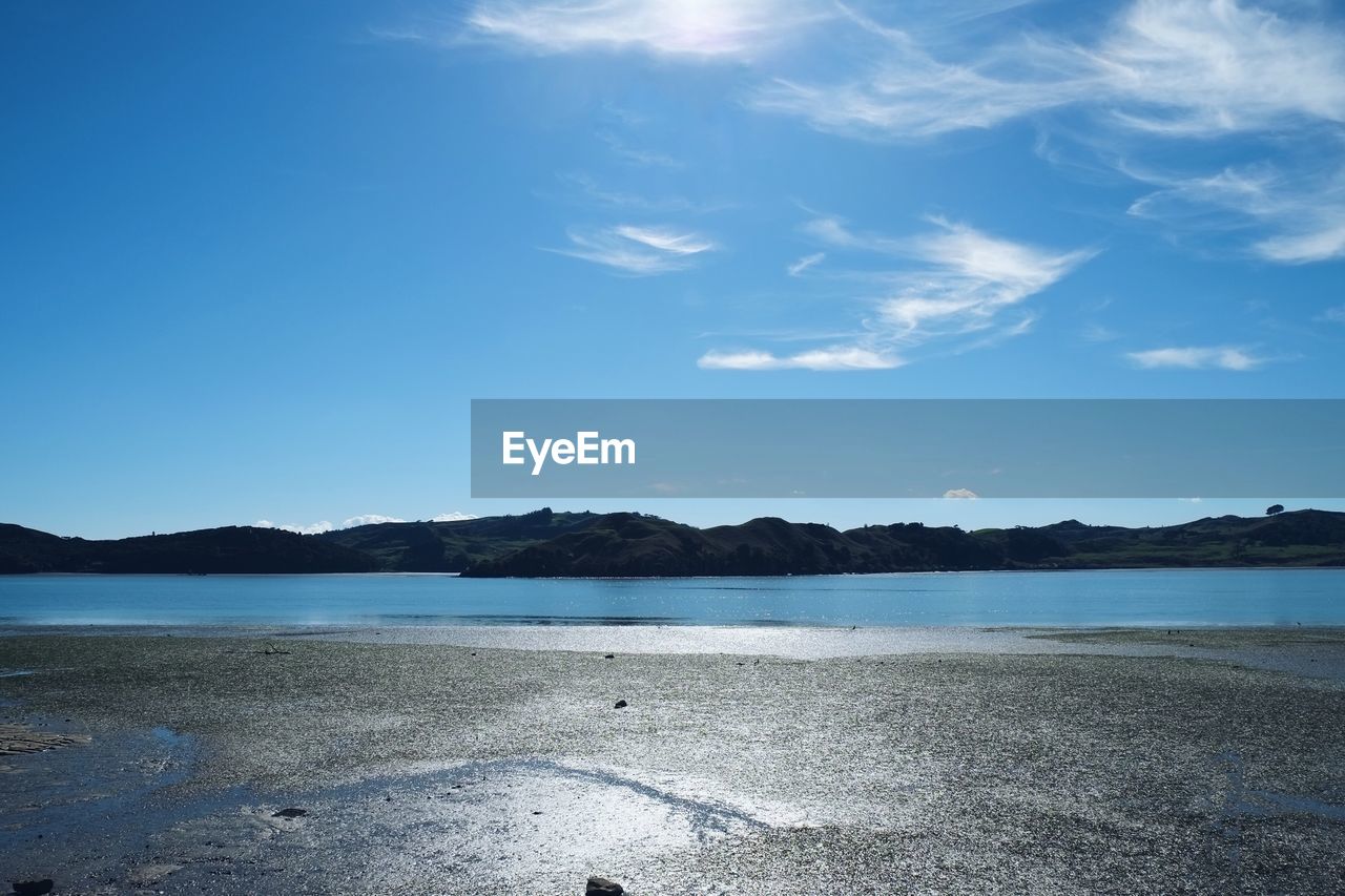 Scenic view of beach against blue sky