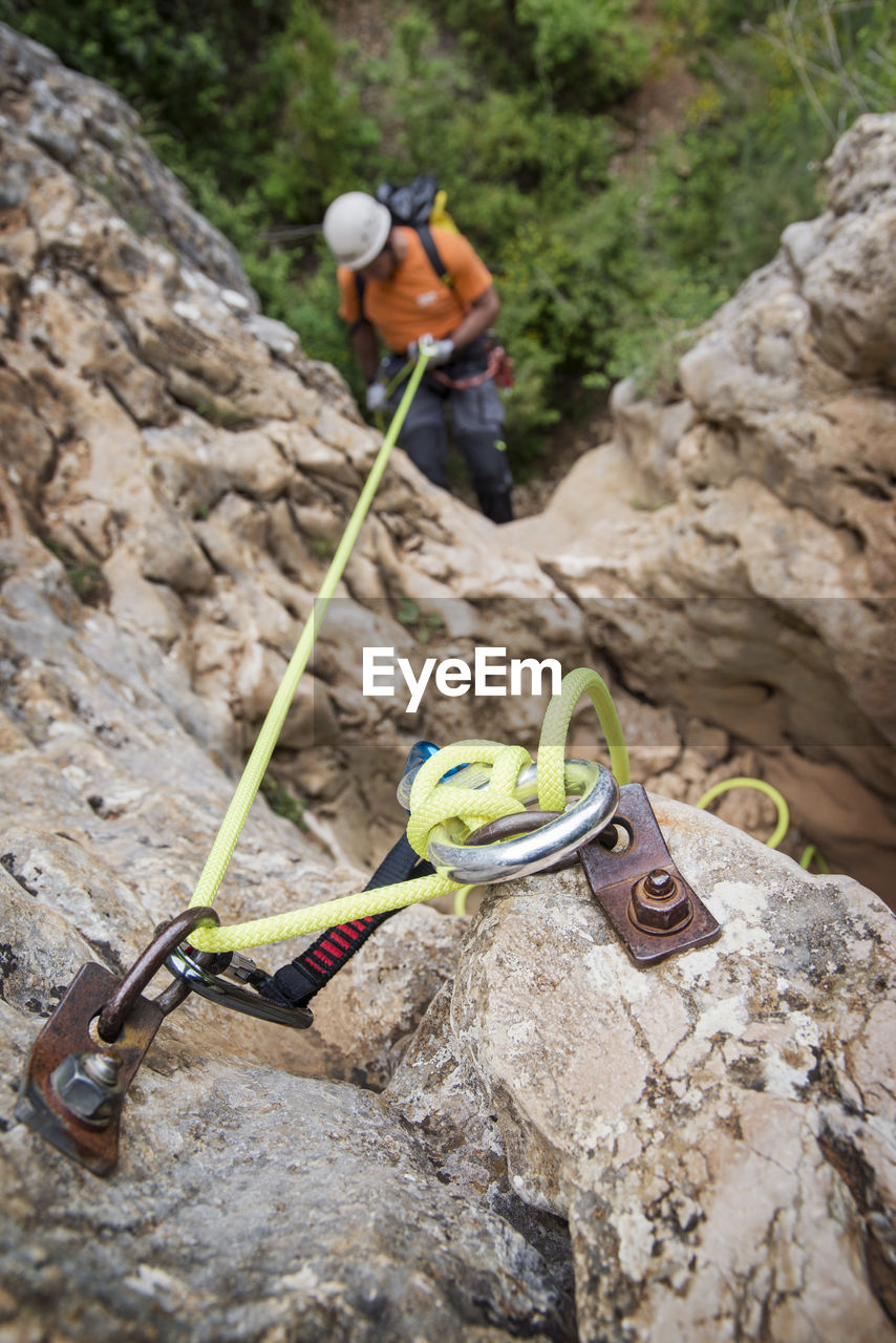 High angle view of man rappelling down the rock