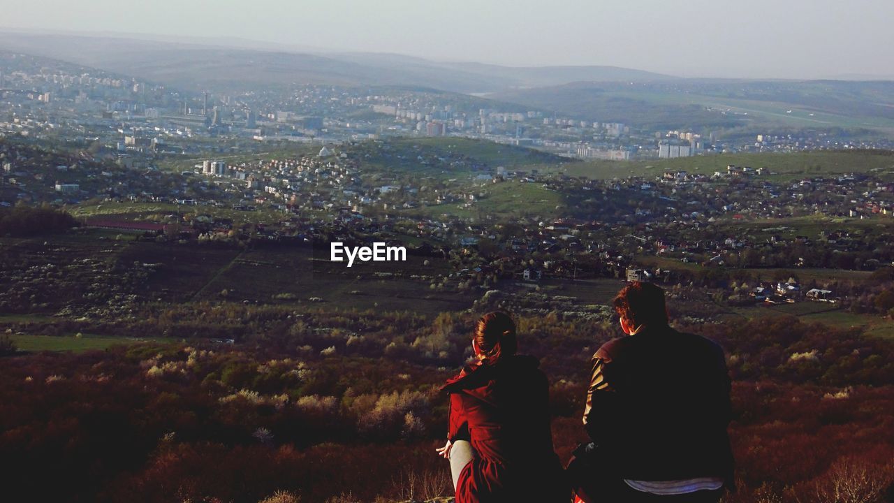 Rear view of couple looking at landscape during sunset