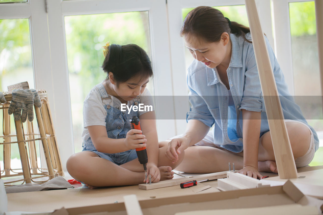 Mother and daughter doing carpentry at home