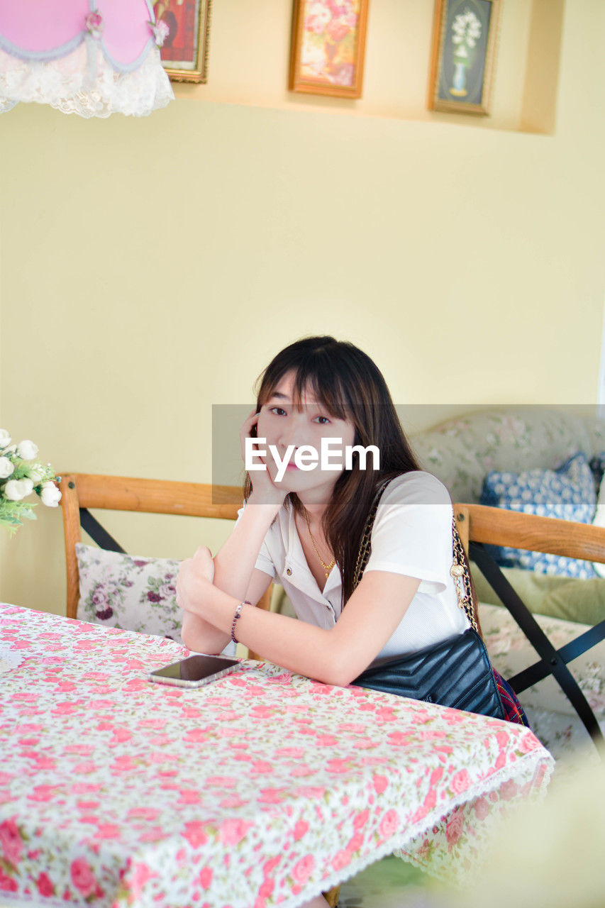 portrait of young woman sitting on bed