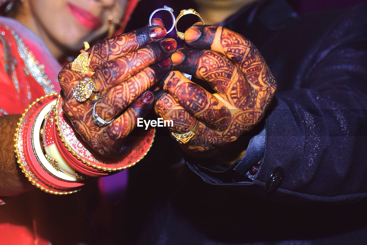 Young indian married couple showing off their rings to the camera